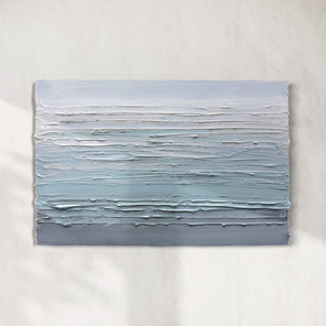 A white, teal and grey heavily textured abstract painting like sculpture by Teodora Guererra hangs on a white wall in natural light.