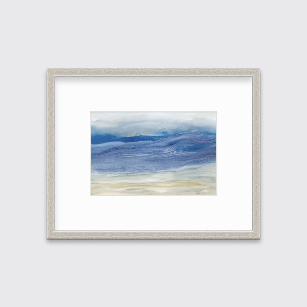 A blue, white and beige abstract print in a silver frame with a mat hangs on a white wall.