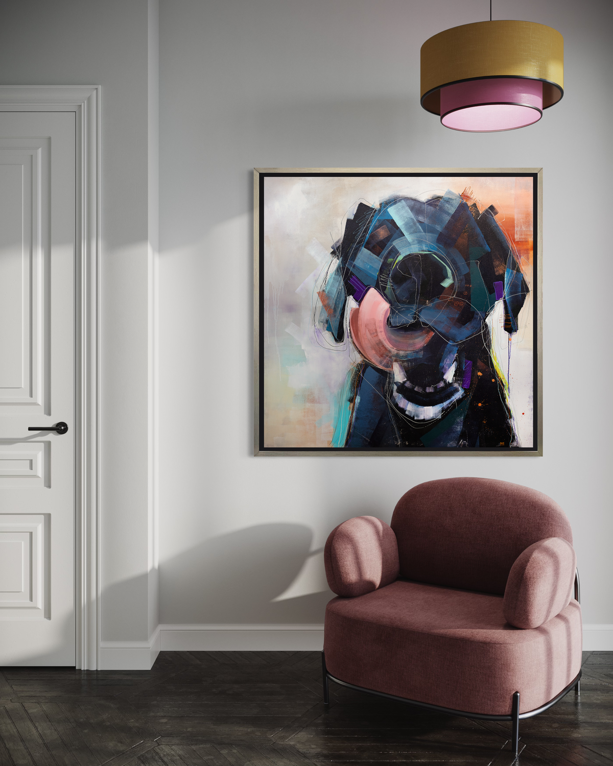 A dark blue, black, purple and copper abstract dog print in a silver floater frame hangs on a white wall above a dark mauve armchair and below a yellow and pink pendant light.