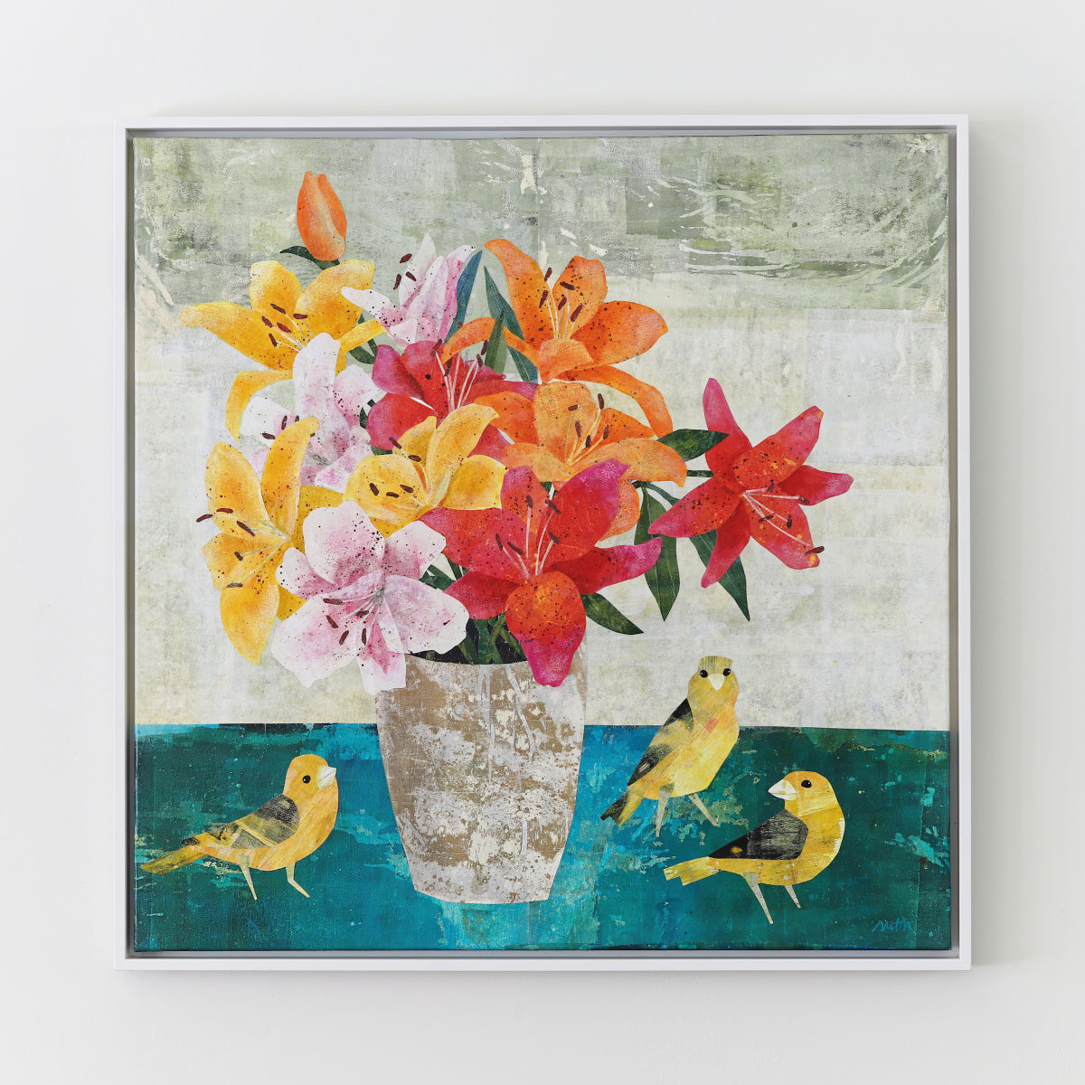 A framed square collage painting depicting a vibrant bouquet of yellow, orange, pink, and red lilies in a textured white vase, with three small yellow birds on a teal surface against a light gray background.