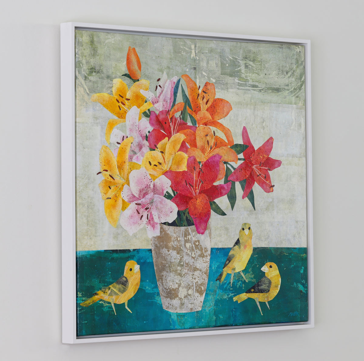 A framed mixed-media floral painting featuring vibrant yellow, orange, pink, and red lilies in a textured beige vase, with three yellow birds on a teal surface against a light gray background.