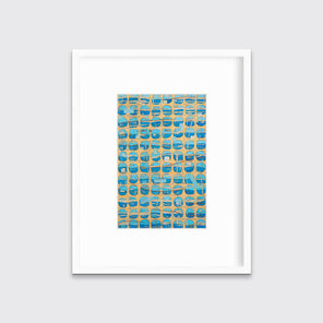 An orange, blue and light blue abstract print in a white frame with a mat hangs on a white wall.