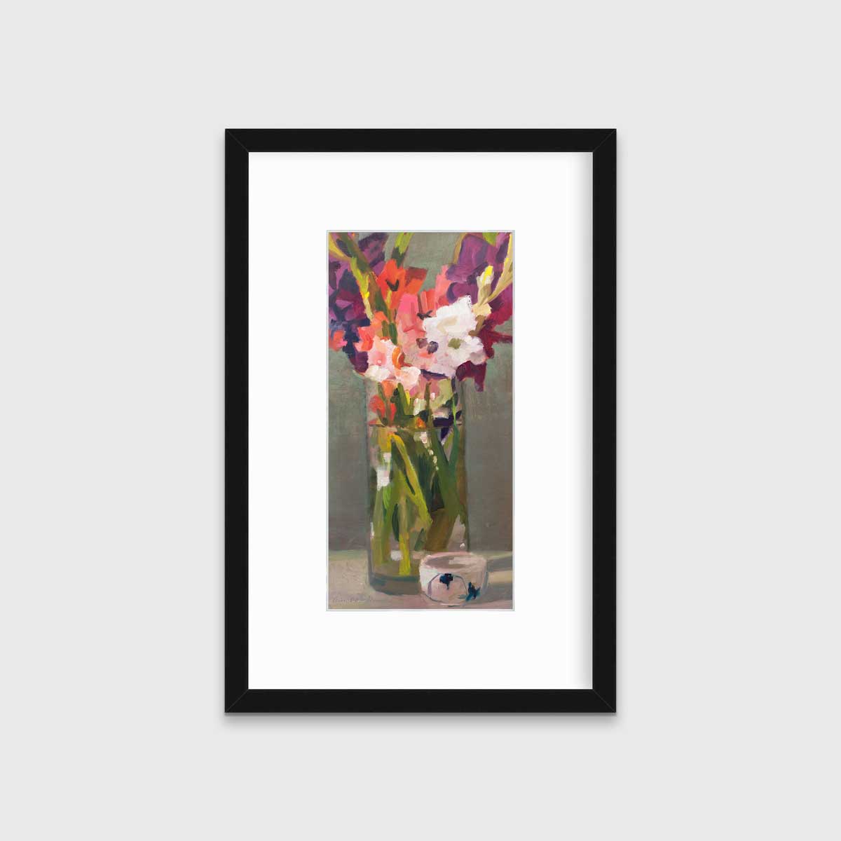 A purple, pink and green abstract floral print in a black frame with a mat hangs on a white wall.