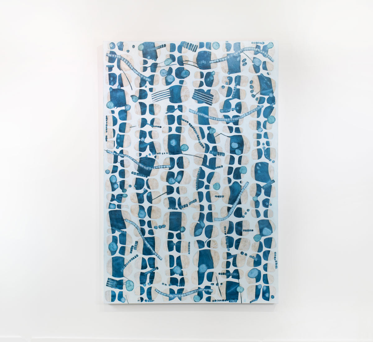 An abstract blue, white, and beige painting hangs on a white wall.