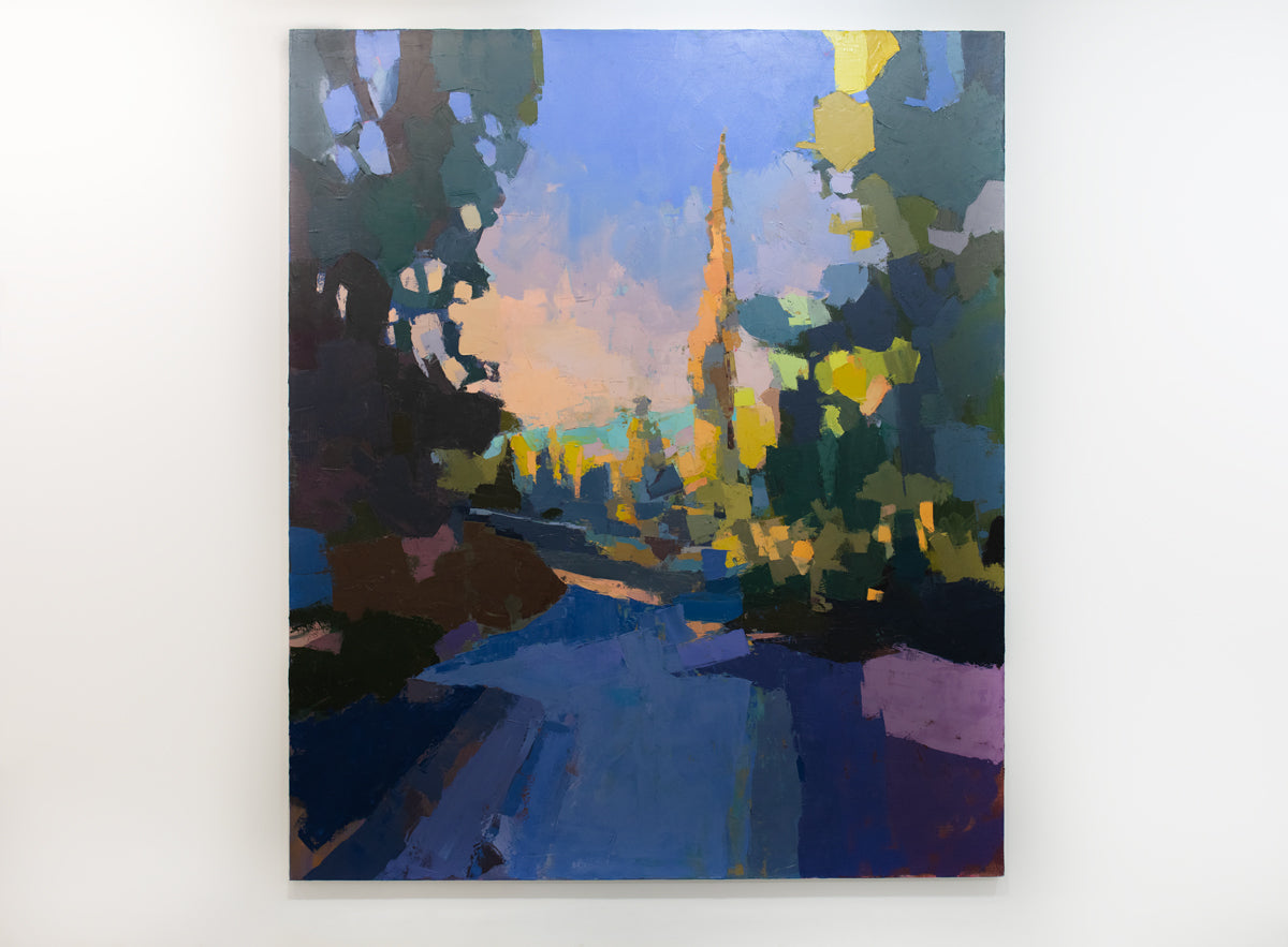 A blue and yellow abstracted landscape painting hangs on a white wall. 