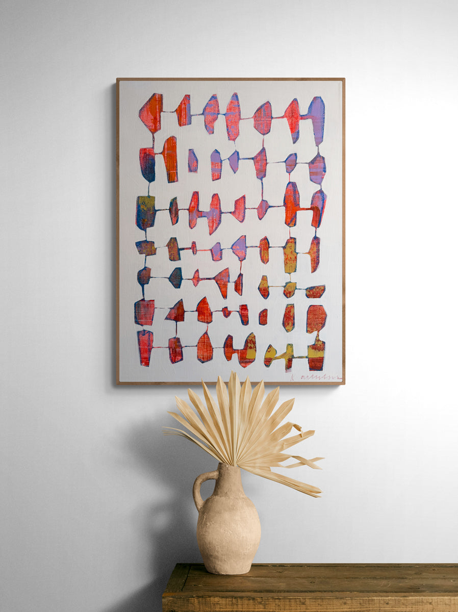Colorful abstract art piece on a wall above a wooden shelf with a decorative vase.
