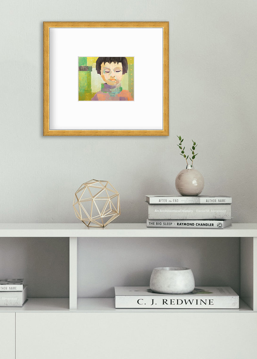 A green, coral, beige and brown abstract figural print in a gold frame with a mat hangs on a white wall above a white shelf with books, a gold wire sphere decoration and a small grey ornament vase with greenery stems.
