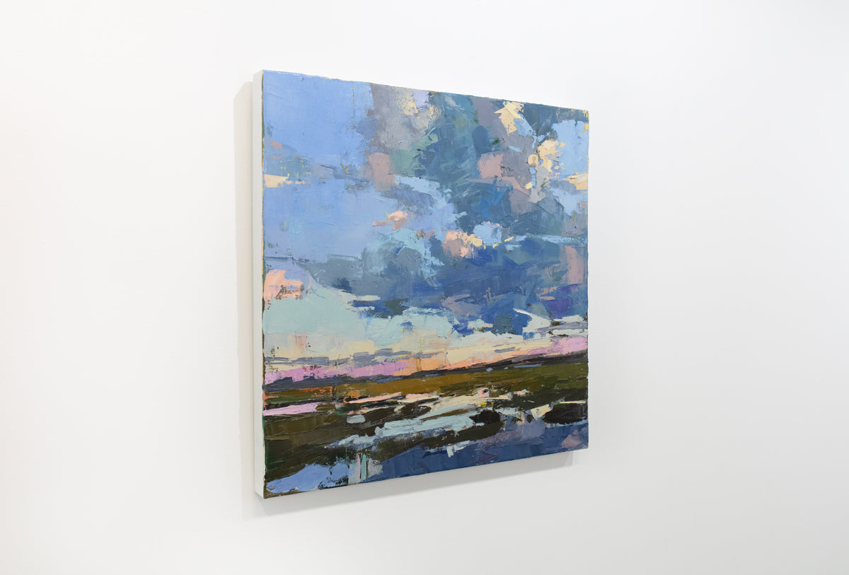 A blue abstract landscape painting hangs on a white wall.