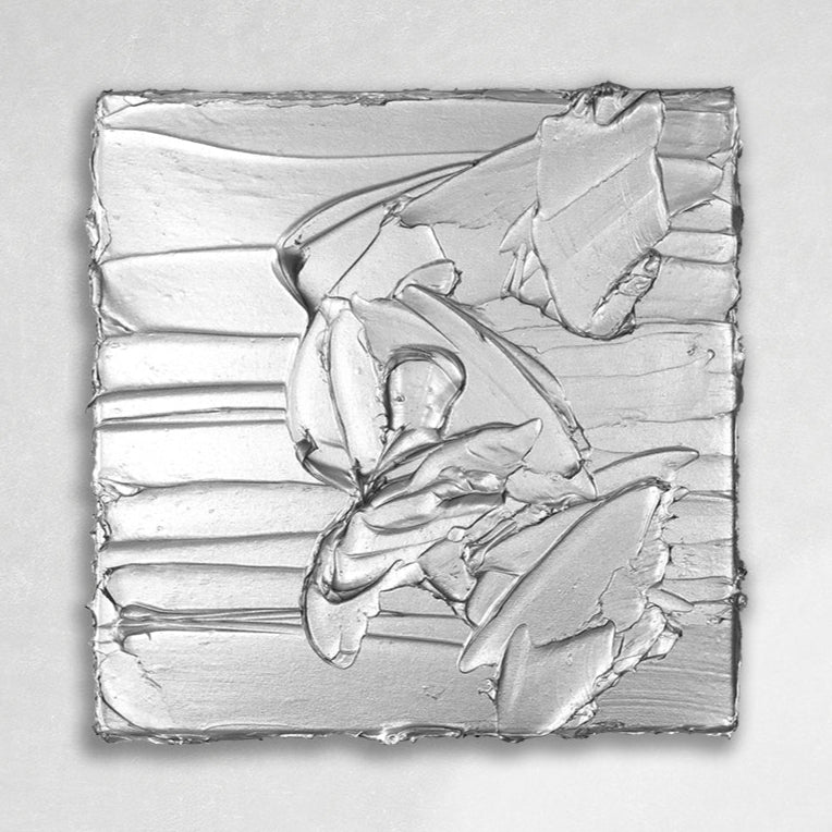 A silver metallic textured painting by Teodora Guererra hanging on a gallery wall.