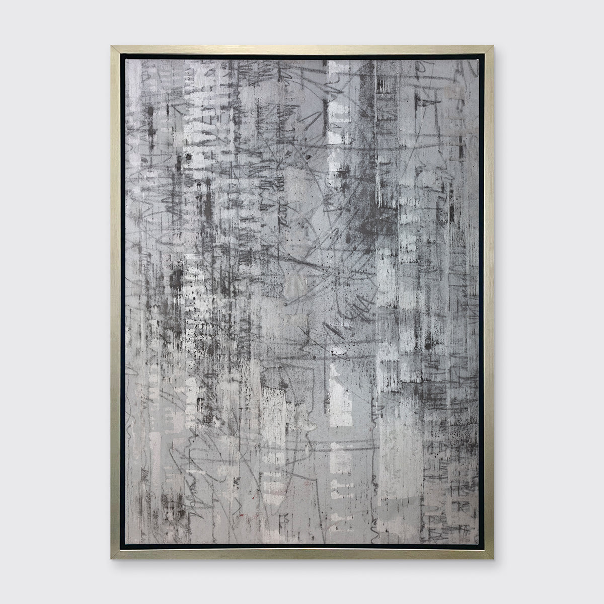 An abstract silver-grey limited edition art print by Ned Martin in a silver frame hangs on a white wall.