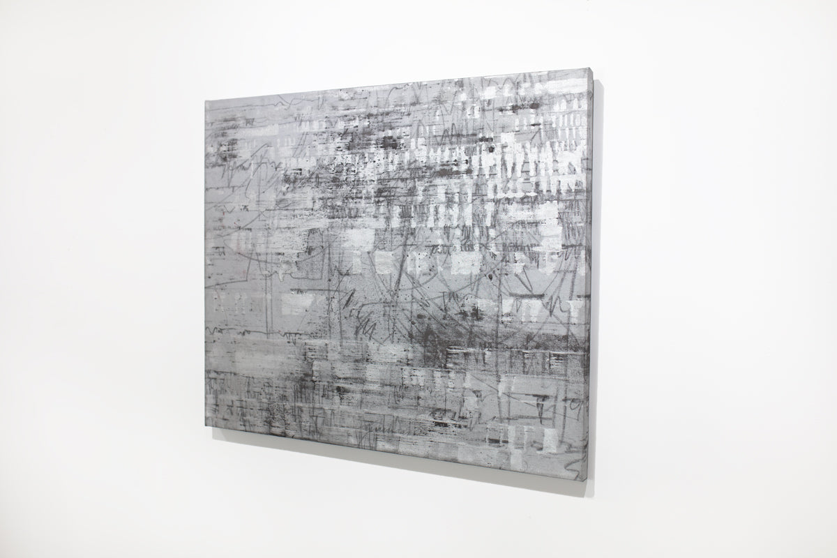 A black and silver abstract painting hangs on a white wall.
