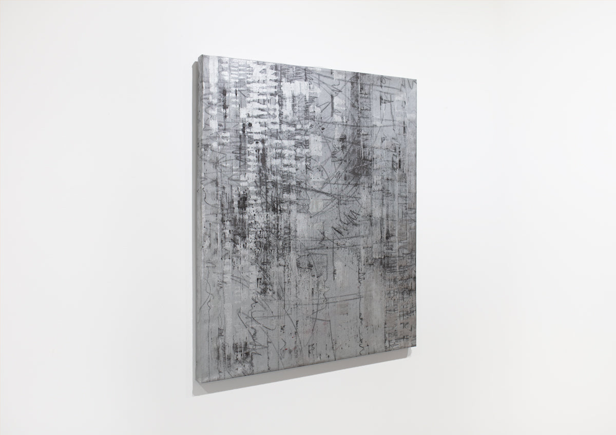 A black and silver abstract painting hangs on a white wall.