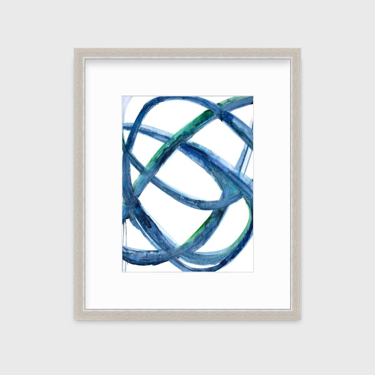 A blue, green and white abstract print in a silver frame with a mat hangs on a white wall.