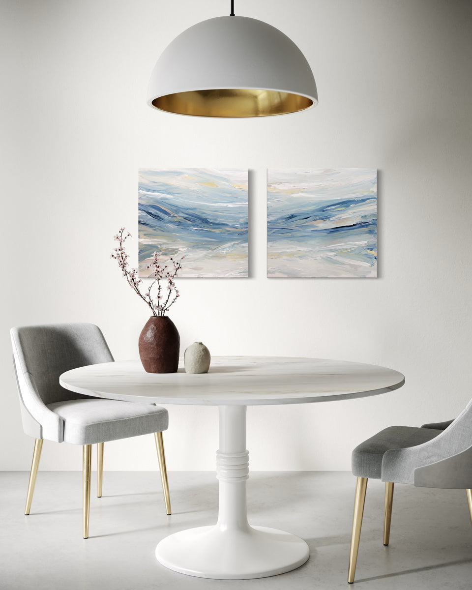 Modern dining room with a white round table, gray chairs, and diptych abstract paintings by Teo Guererra.