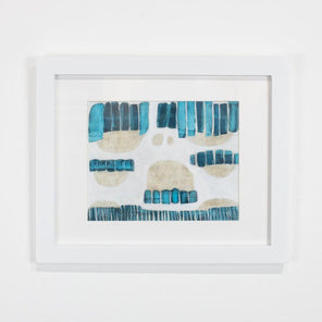 A blue, beige, and white abstract painting framed in a white frame hangs on a white wall. 