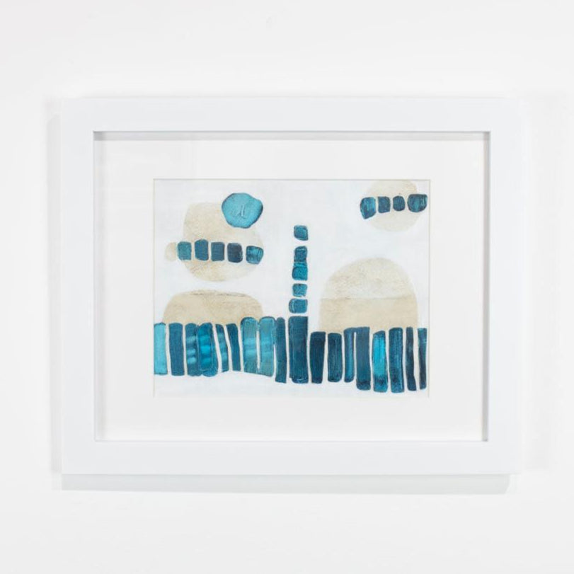 A blue, white, and beige abstract painting framed in a white frame hangs on a white wall. 