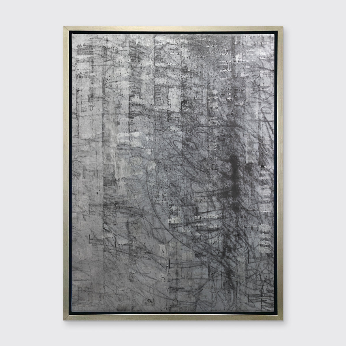 An abstract silver-grey limited edition art print by Ned Martin in a silver frame hangs on a white wall.