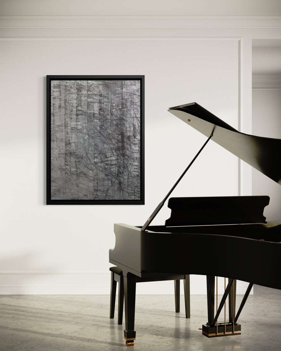 An abstract silver-grey limited edition art print by Ned Martin in a black frame hangs on a white wall in a room with a black grand piano.