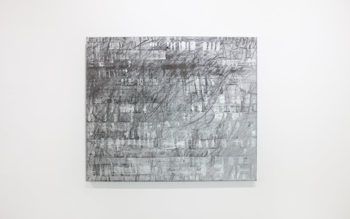 A black and silver abstract painting hangs on a white wall. 