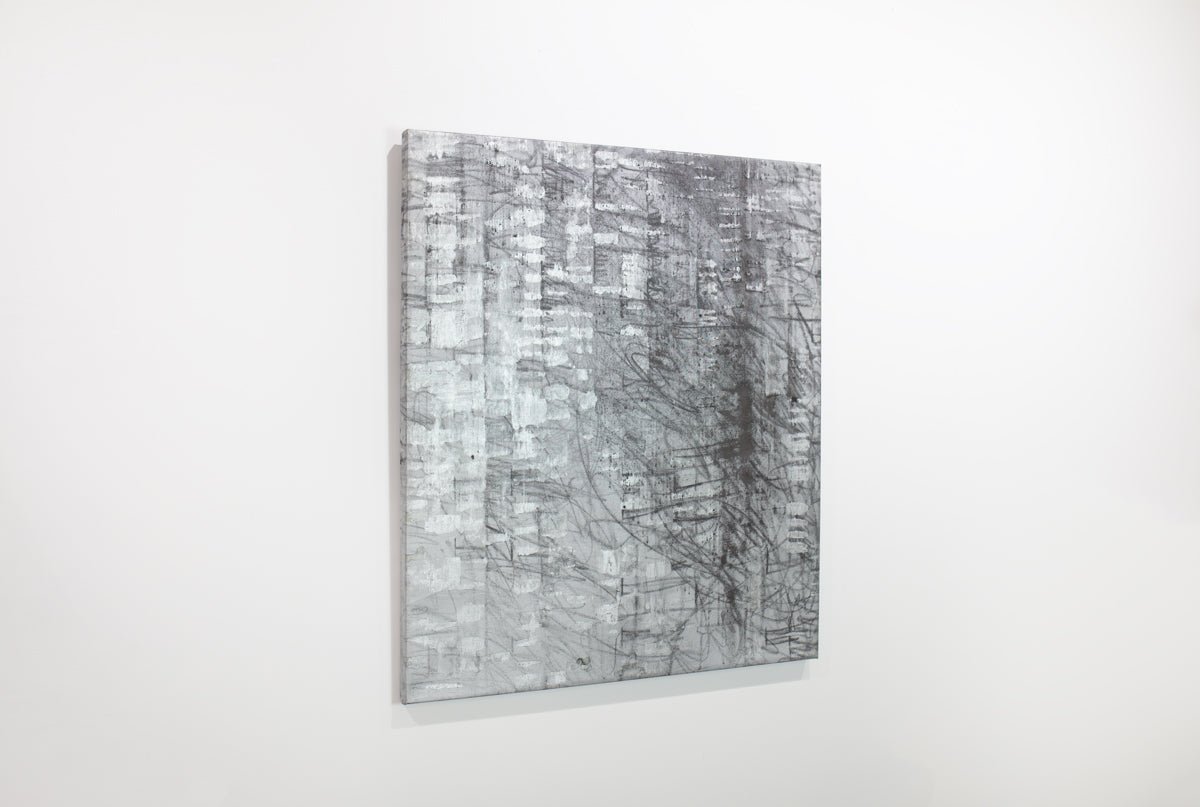 A black and silver abstract painting hangs on a white wall.