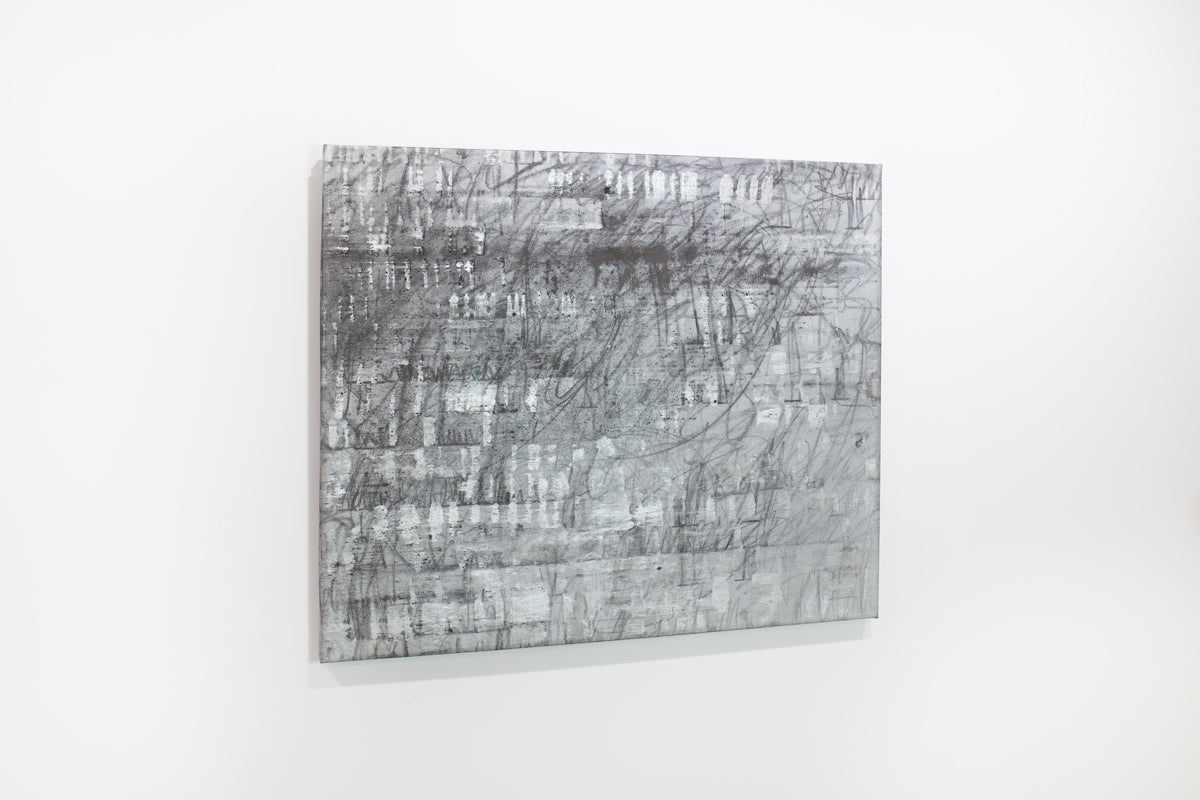 A black and silver abstract painting hangs on a white wall.