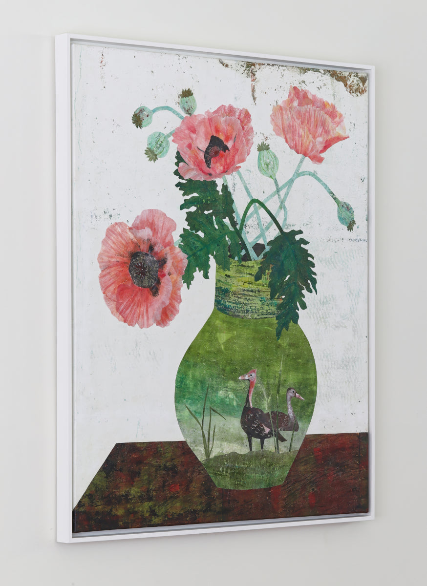 A framed collage featuring a green vase with pink poppy flowers and green leaves, with two birds visible inside the vase, displayed on a light gray wall.