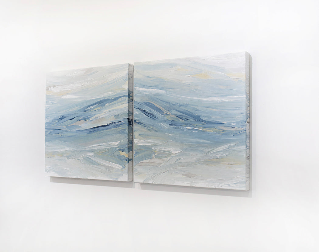 A pair of coastal paintings with blue, grey, white, cream, stone, teal, and yellow ochre paint hanging on a white wall, side view, by Teodora Guererra.
