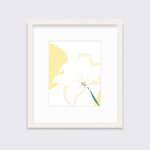 A light yellow abstract botanical art print framed in a white frame hangs on a light wall.