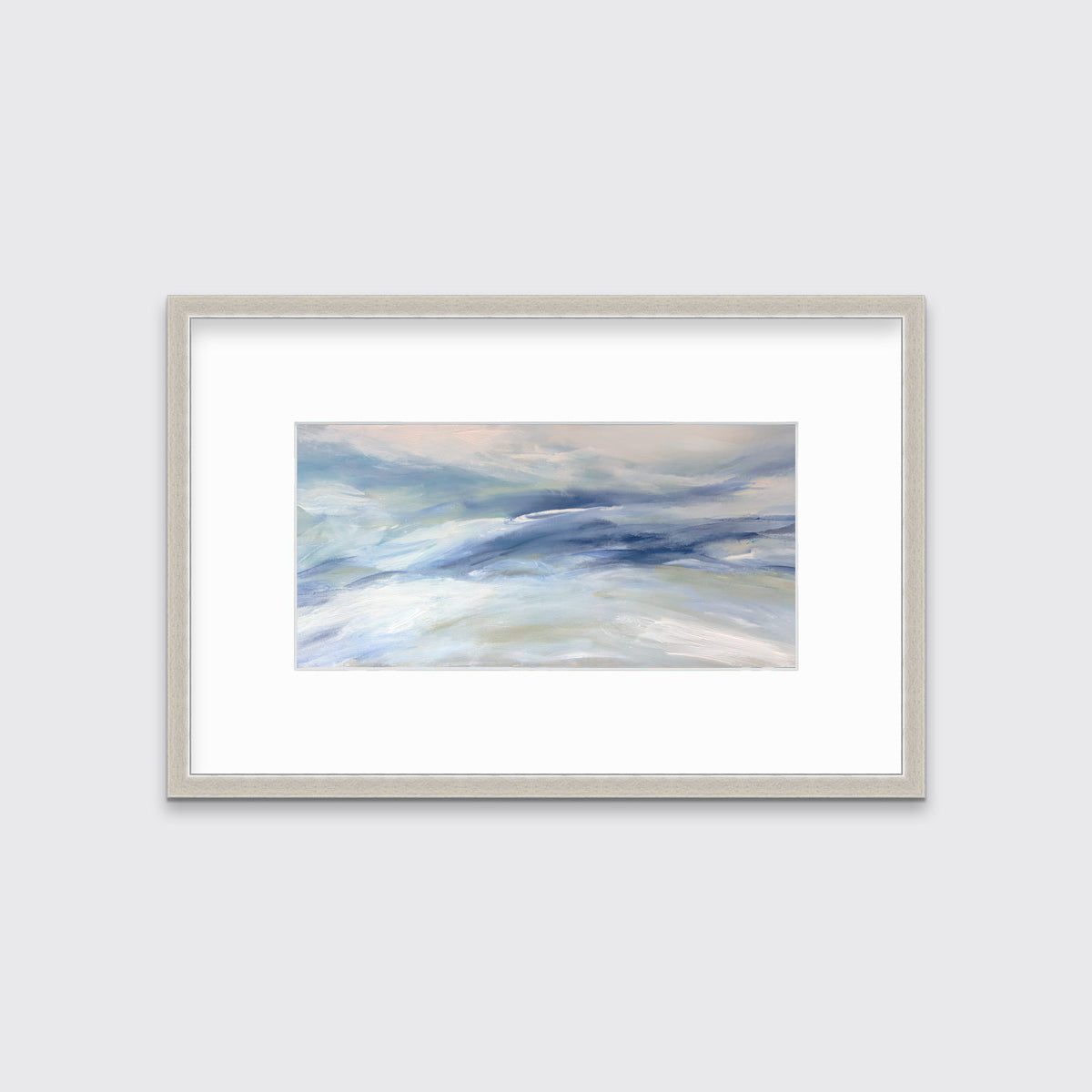 A blue, white and light green abstract print in a silver frame with a mat hangs on a white wall.