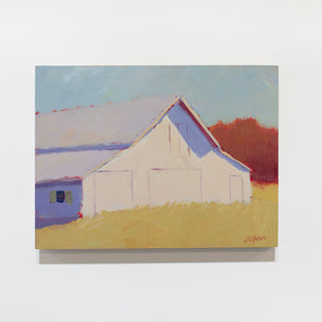 A landscape painting of a barn in a field hangs on a white wall. 