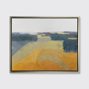 A light blue, green and light orange abstract landscape print in a silver floater frame hangs on a white wall.