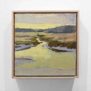 A framed yellow and brown abstracted landscape painting hangs on a white wall.