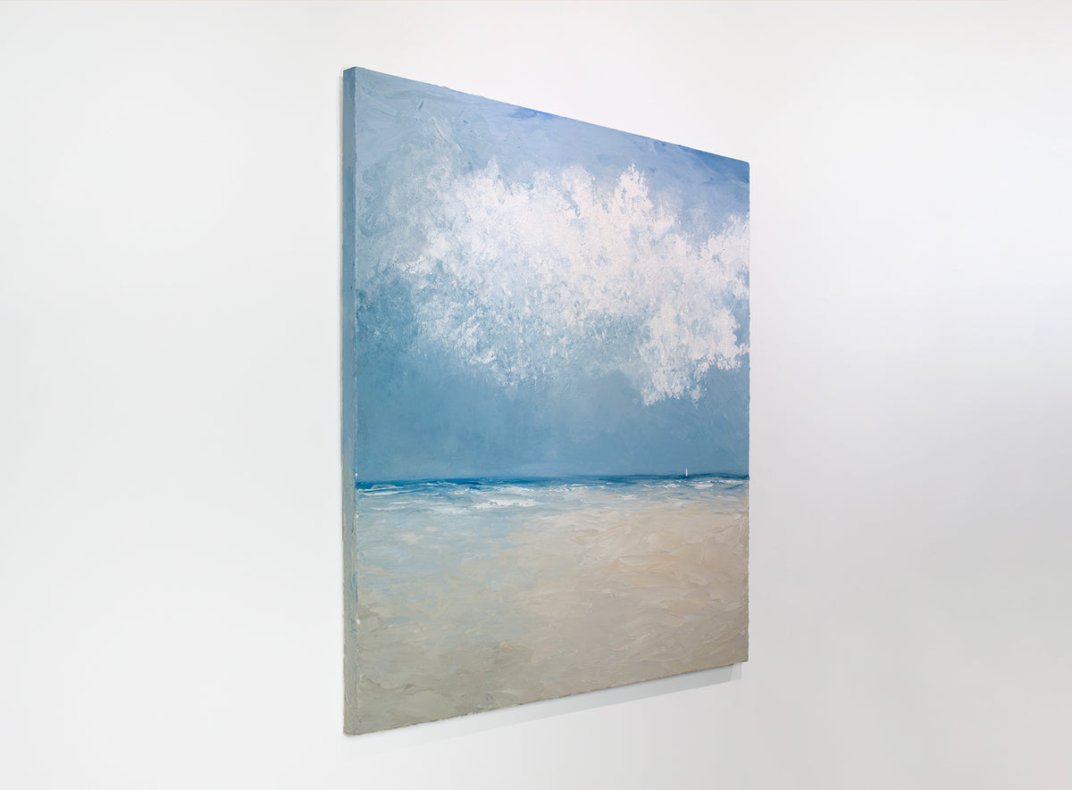 A side view of an abstract coastal seascape painting hangs on a white wall.