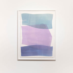 An abstract blue and violet abstract watercolor painting framed in a white frame hangs on a white wall. 