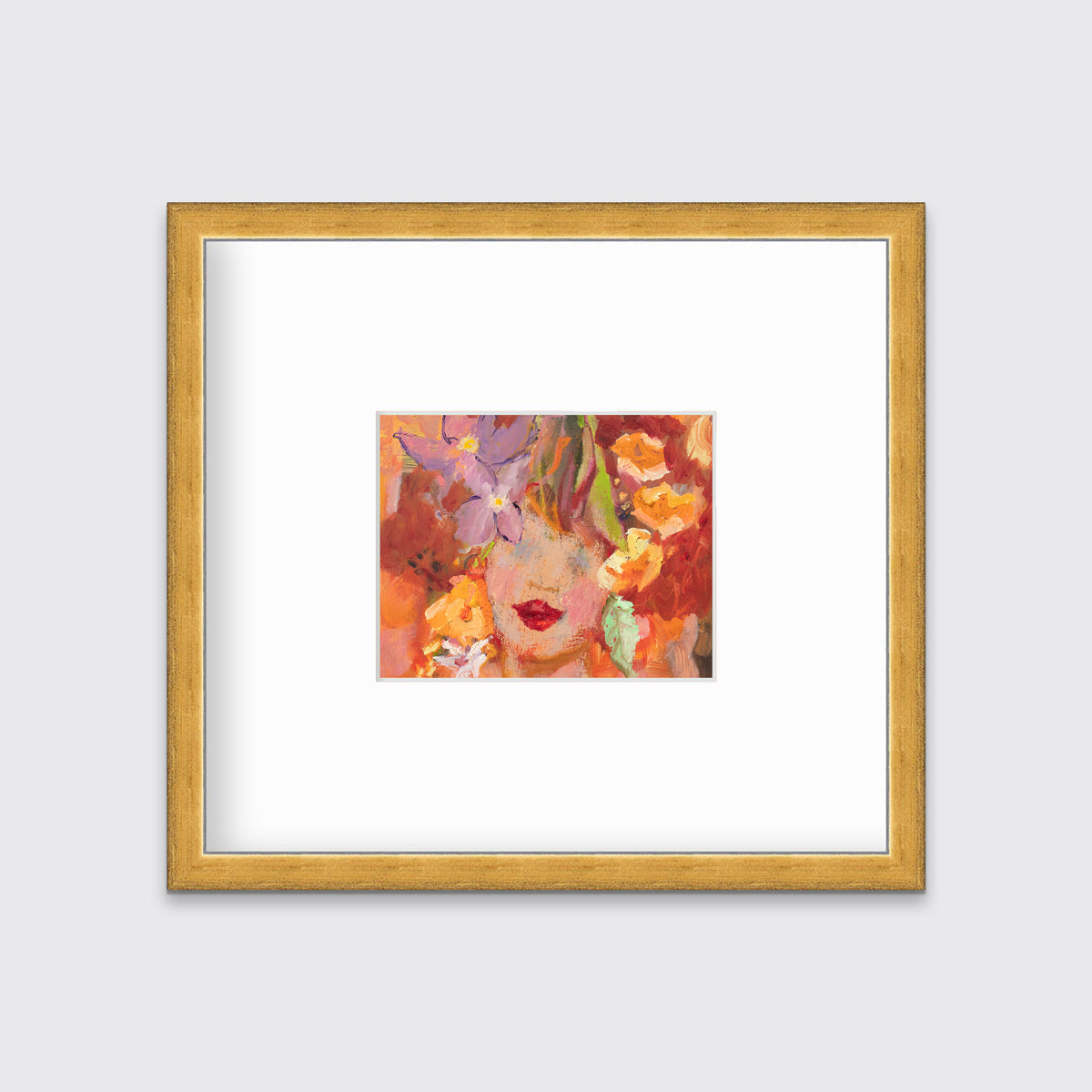 A red, orange, yellow and purple figural print in a gold frame with a mat hangs on a white wall.
