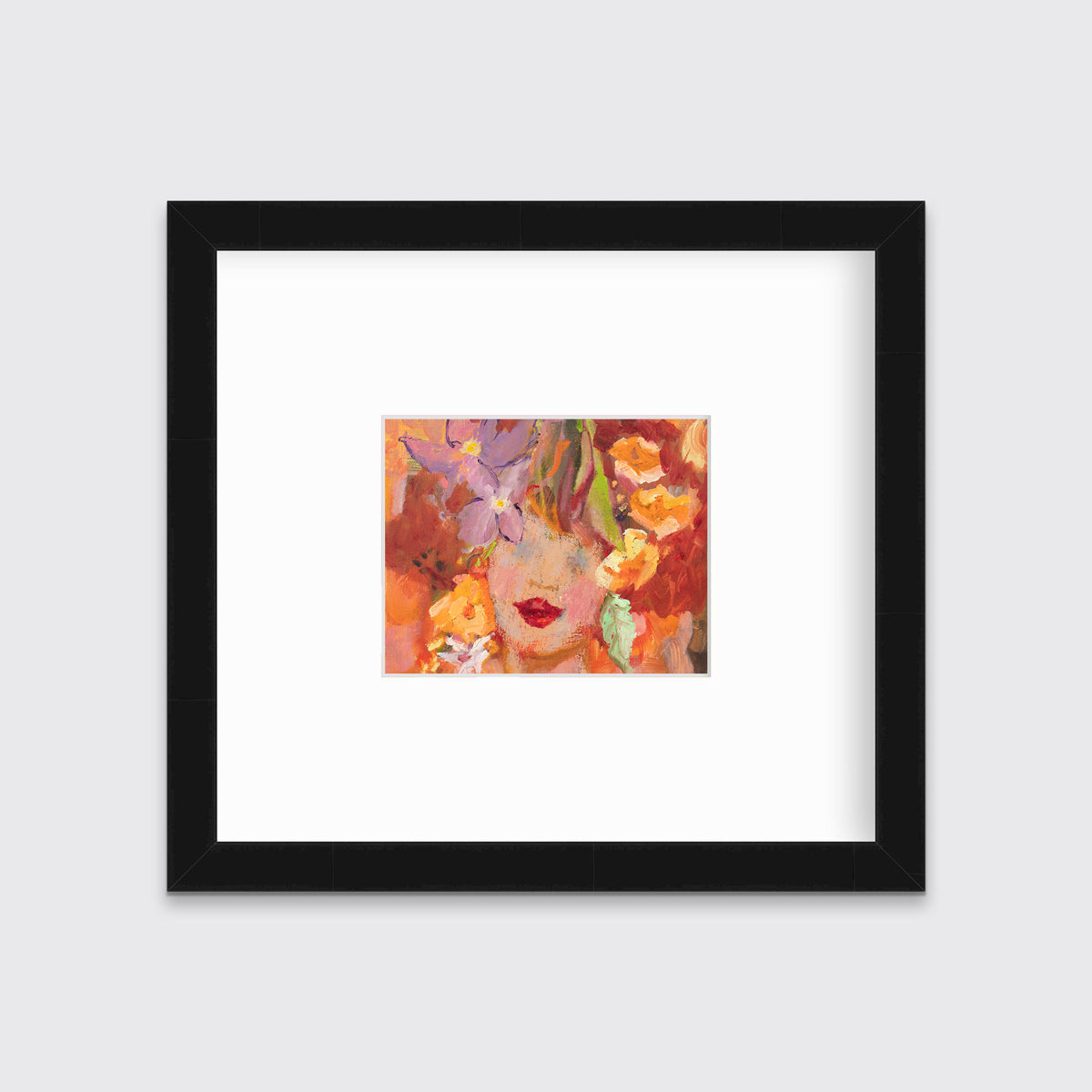 A red, orange, yellow and purple figural print in a black frame with a mat hangs on a white wall.
