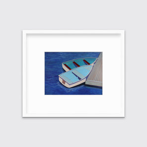 A blue, light blue and beige contemporary nautical print of two docked rowboats in a white frame with a mat hangs on a white wall.