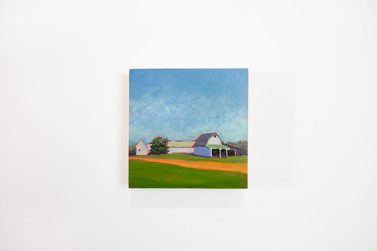 A blue, green, and orange landscape painting hangs on a white wall. 