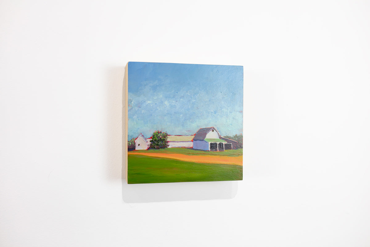 A blue, green, and orange landscape painting hangs on a white wall.