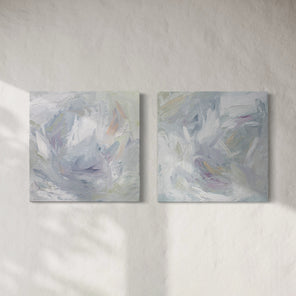 A pair of thickly painted paintings in teal, sea foam green, celadon, white, lavender and yellow by Teodora Guererra hang on a white wall.