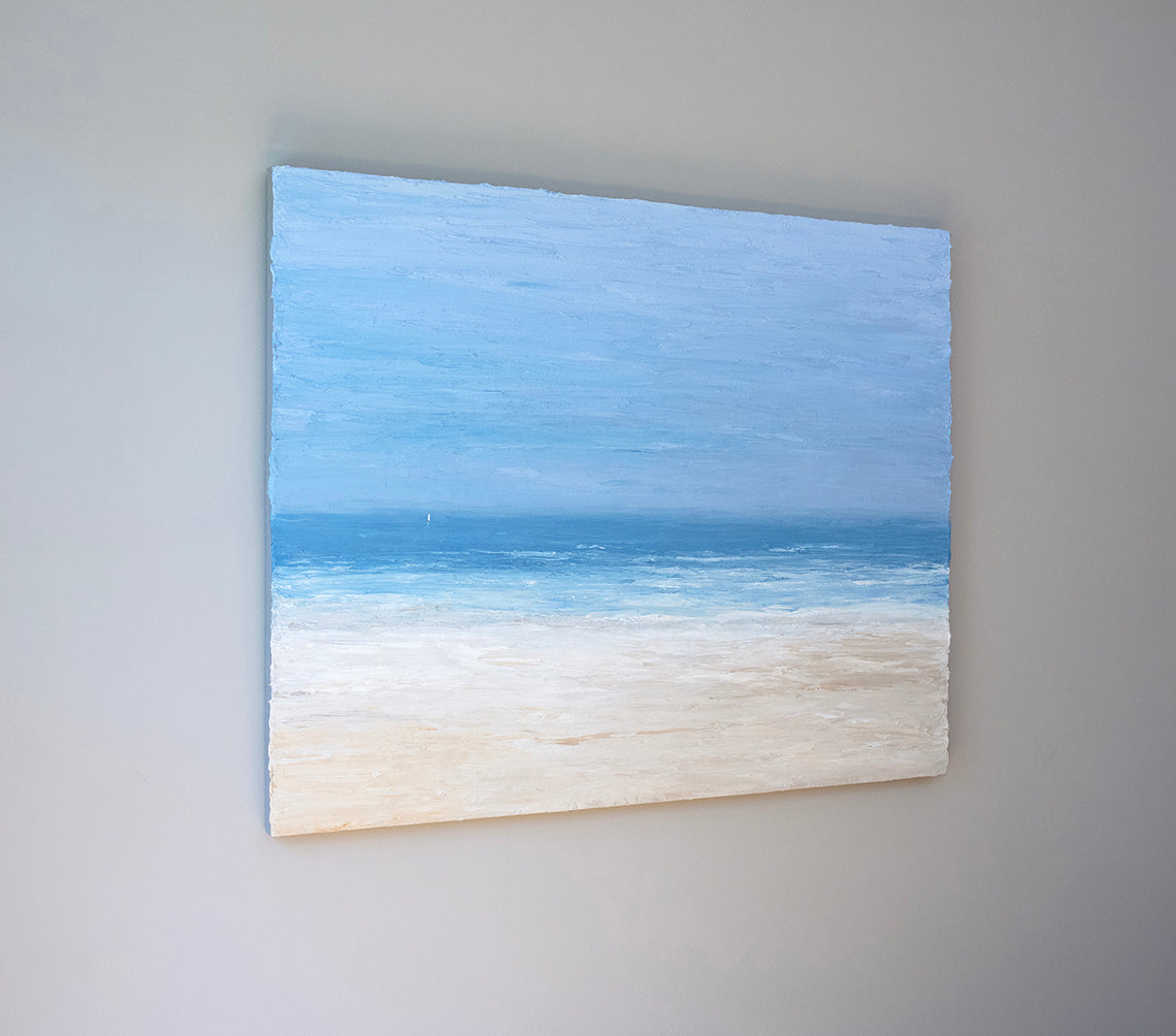 A side view of a very thick painted coastal seascape with a loan sailboat hangs on a grey wall.