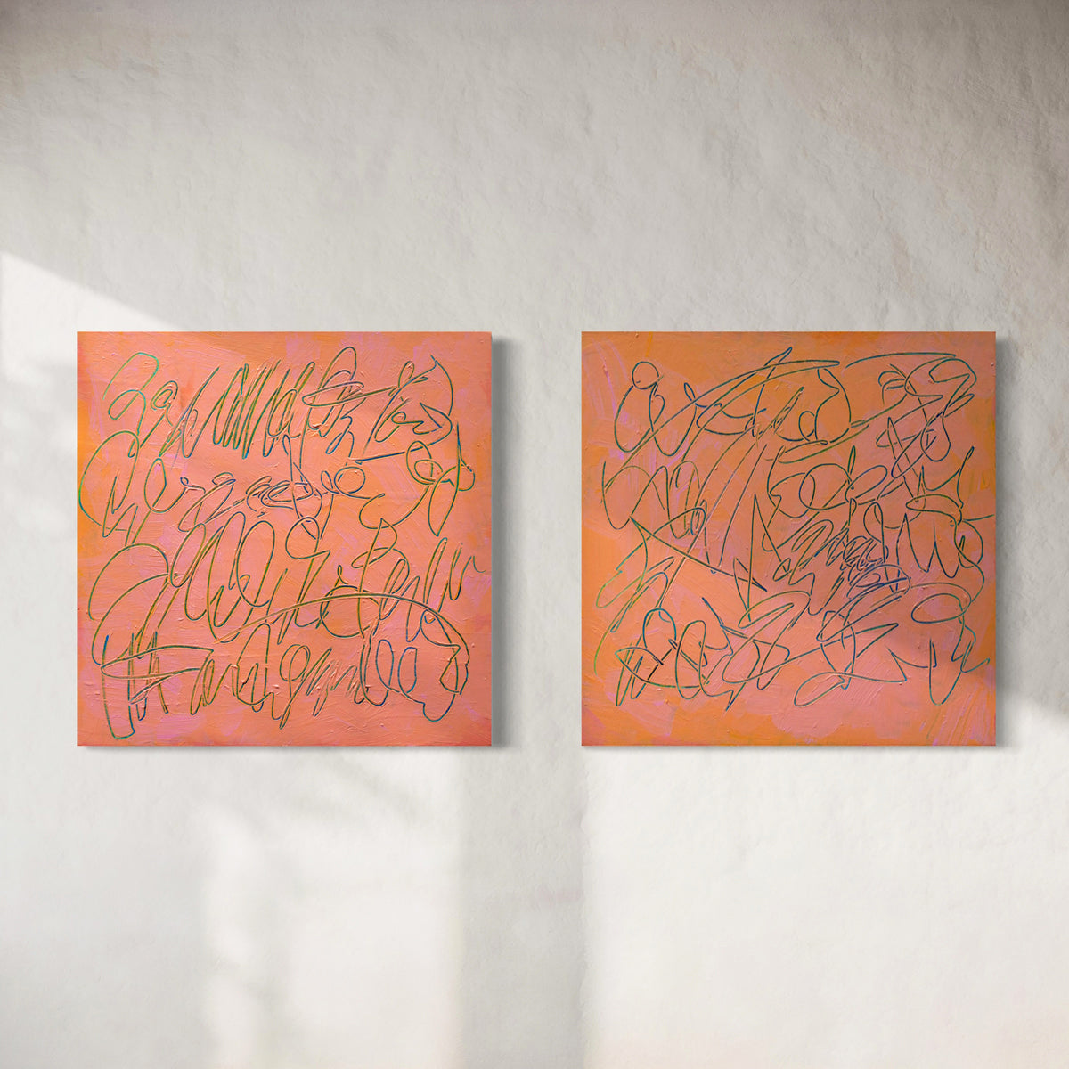 Two abstract square paintings with peach, pink, and orange backgrounds and teal scribbled line work, displayed side by side on a textured off-white wall.