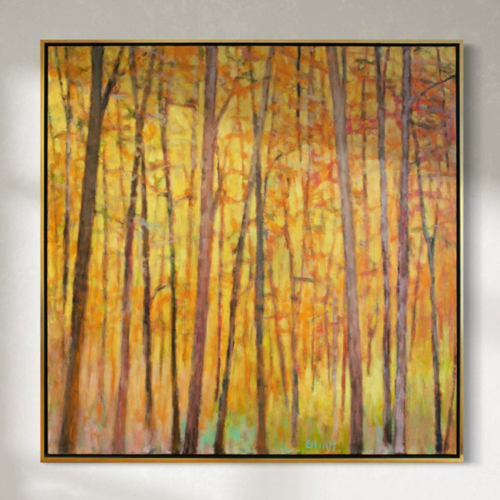An impressionistic painting similar to Wolf Kahn with tall brown trees with orange and red leaves and a warm yellow background hangs on a wall.