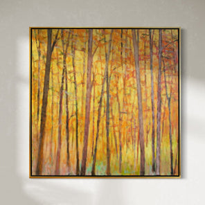 An impressionistic painting similar to Wolf Kahn with tall brown trees with orange and red leaves and a warm yellow background hangs on a wall.