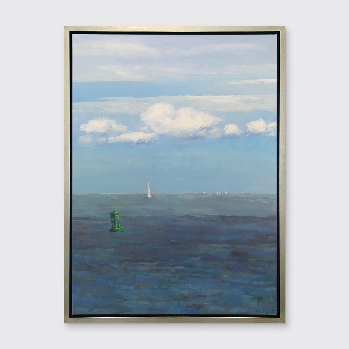A coastal seascape print in a silver floater frame hangs on a white wall.