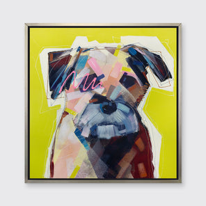 A multicolored abstract dog print in a silver floater frame hangs on a white wall.