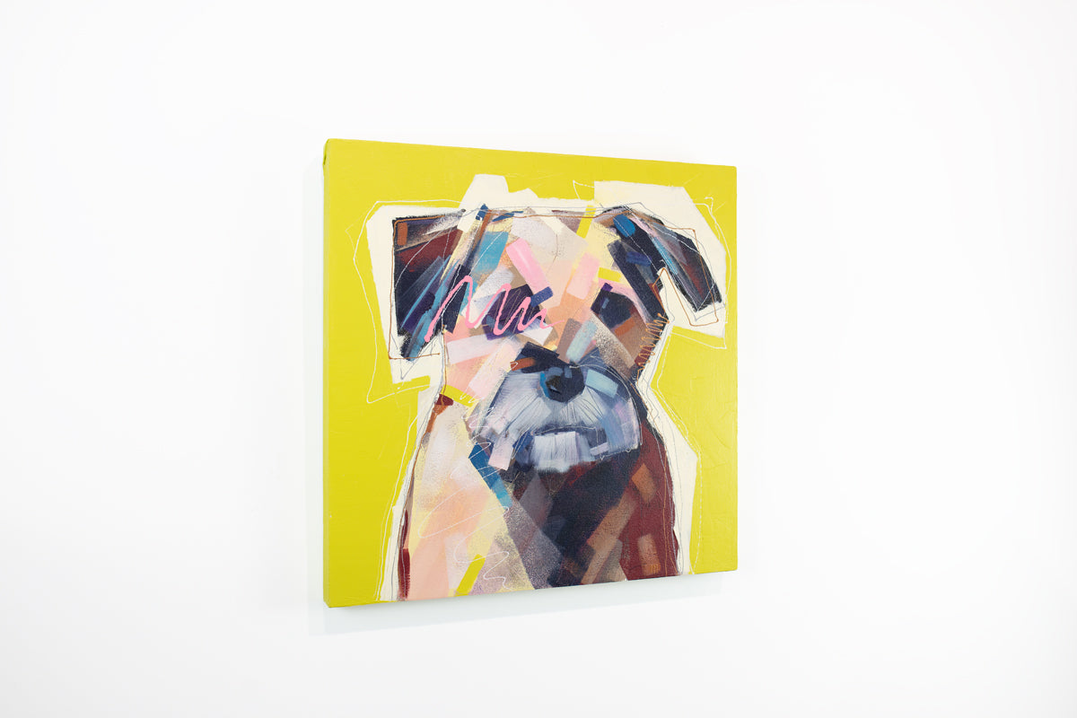 A bright yellow painting of an abstracted dog hangs on a white wall.