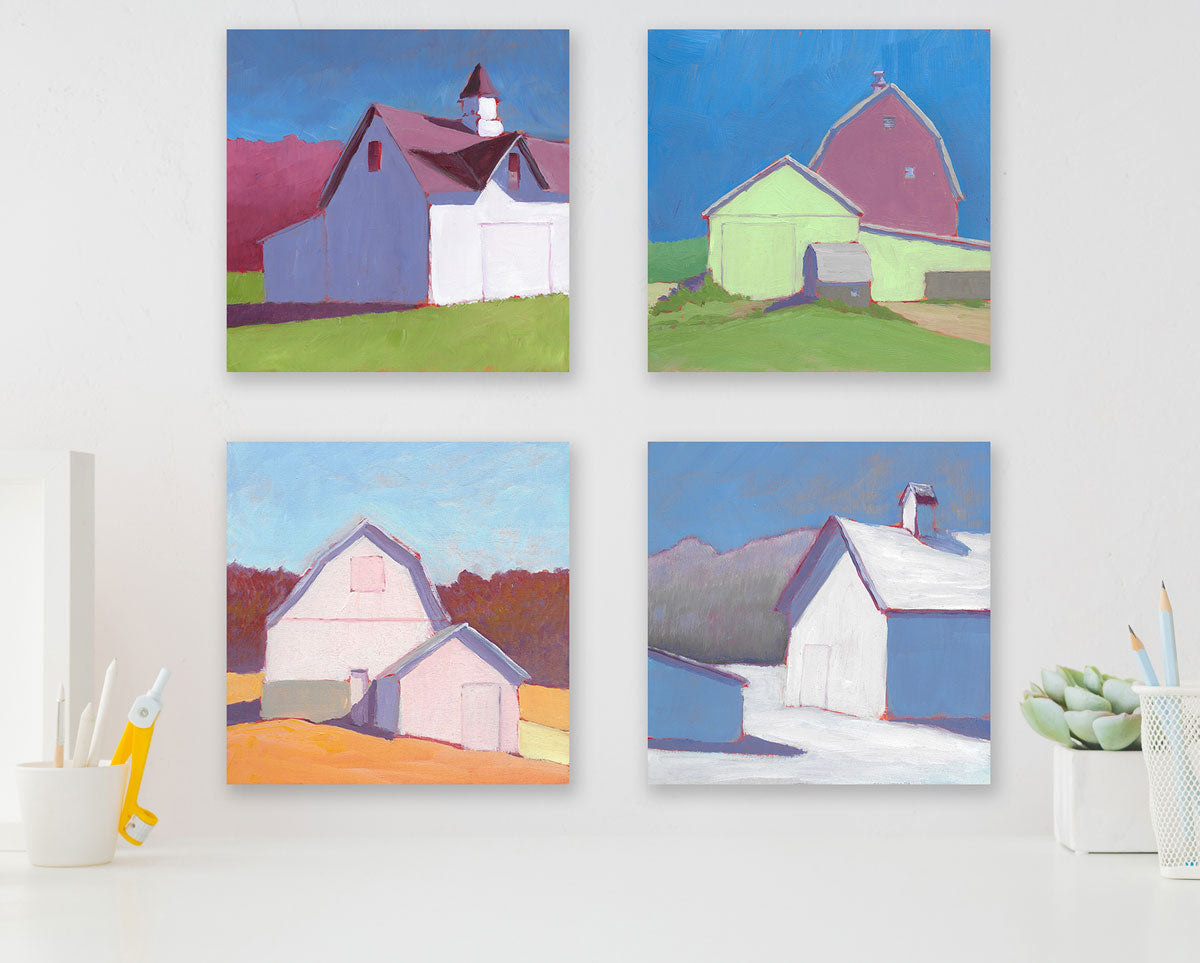 Four colorful contemporary landscape paintings hang on a white wall above a white desk with a small succulent plant and two pencil holders.