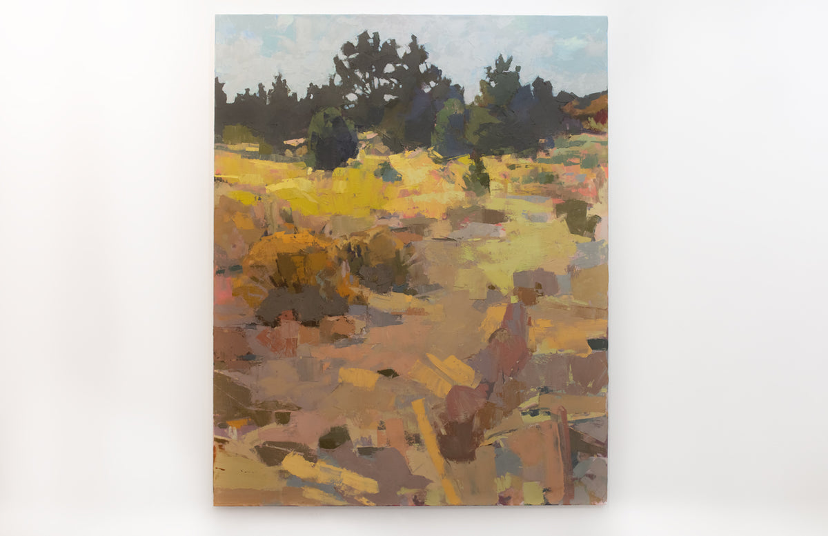 A warm-toned abstracted landscape painting hangs on a white wall. 