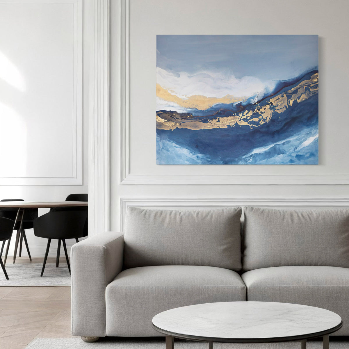 Modern living room with a gray sofa, round coffee table, and abstract painting on the wall.